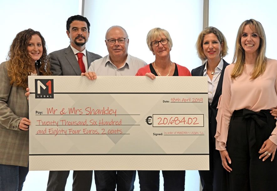 Six people standing indoors holding a large M1 Legal cheque made out to Mr & Mrs Shankley for €20,684.02, dated 18 April 2019