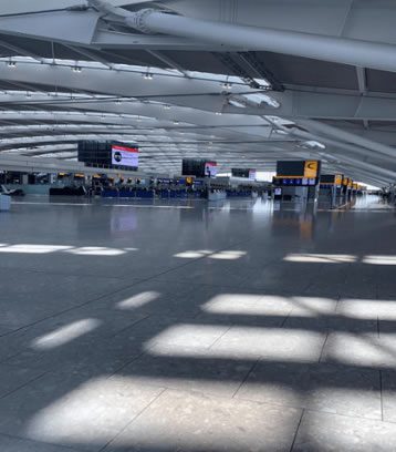 Empty airport terminal with closed check-in desks and digital flight information screens during lockdown