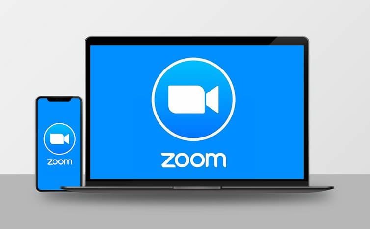 Smartphone and laptop displaying the Zoom logo for Zoom video appointments during Covid-19