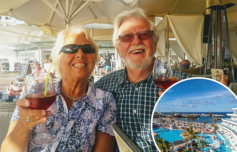 Smiling older couple holding glasses of wine at an outdoor café, with an inset view of a Tenerife resort pool and seafront marina at La Pinta Beach Club