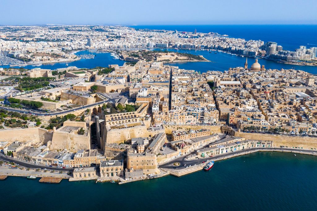 Aerial view of Valletta, Malta, showing the historic peninsula city and surrounding harbours with boats and dense buildings by the sea