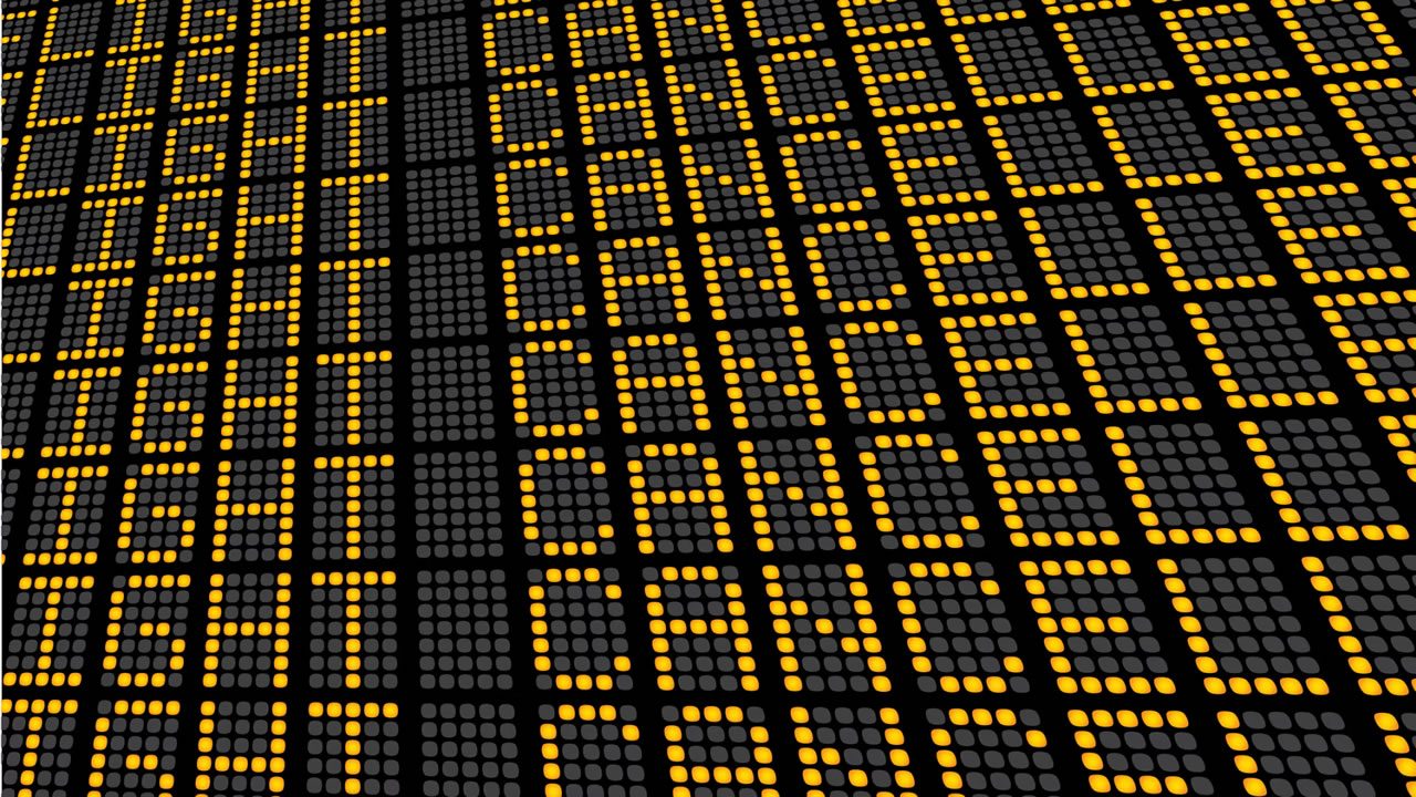 Airport departures board showing rows of cancelled flights in amber dot-matrix text
