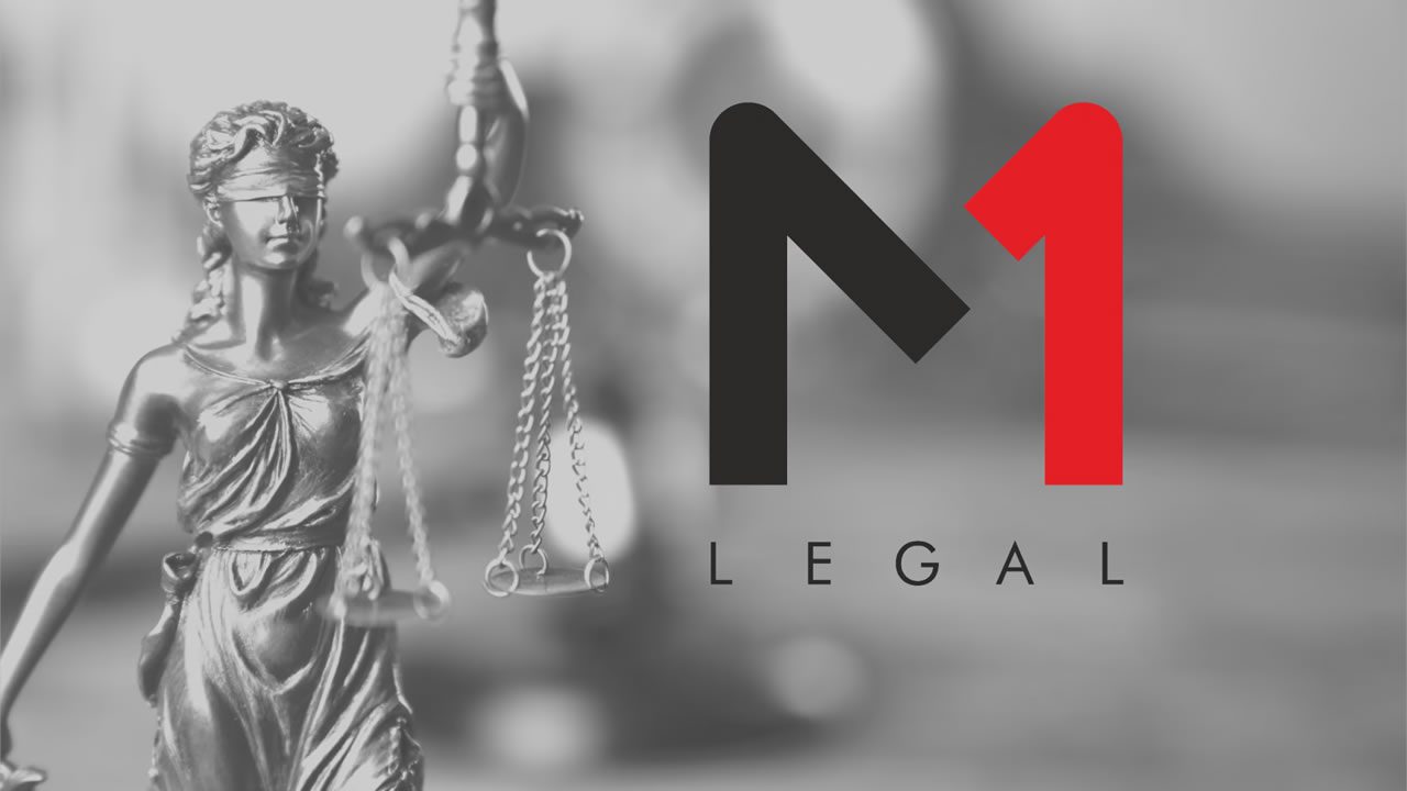 Lady Justice statue holding scales beside the M1 Legal logo on a blurred grey background