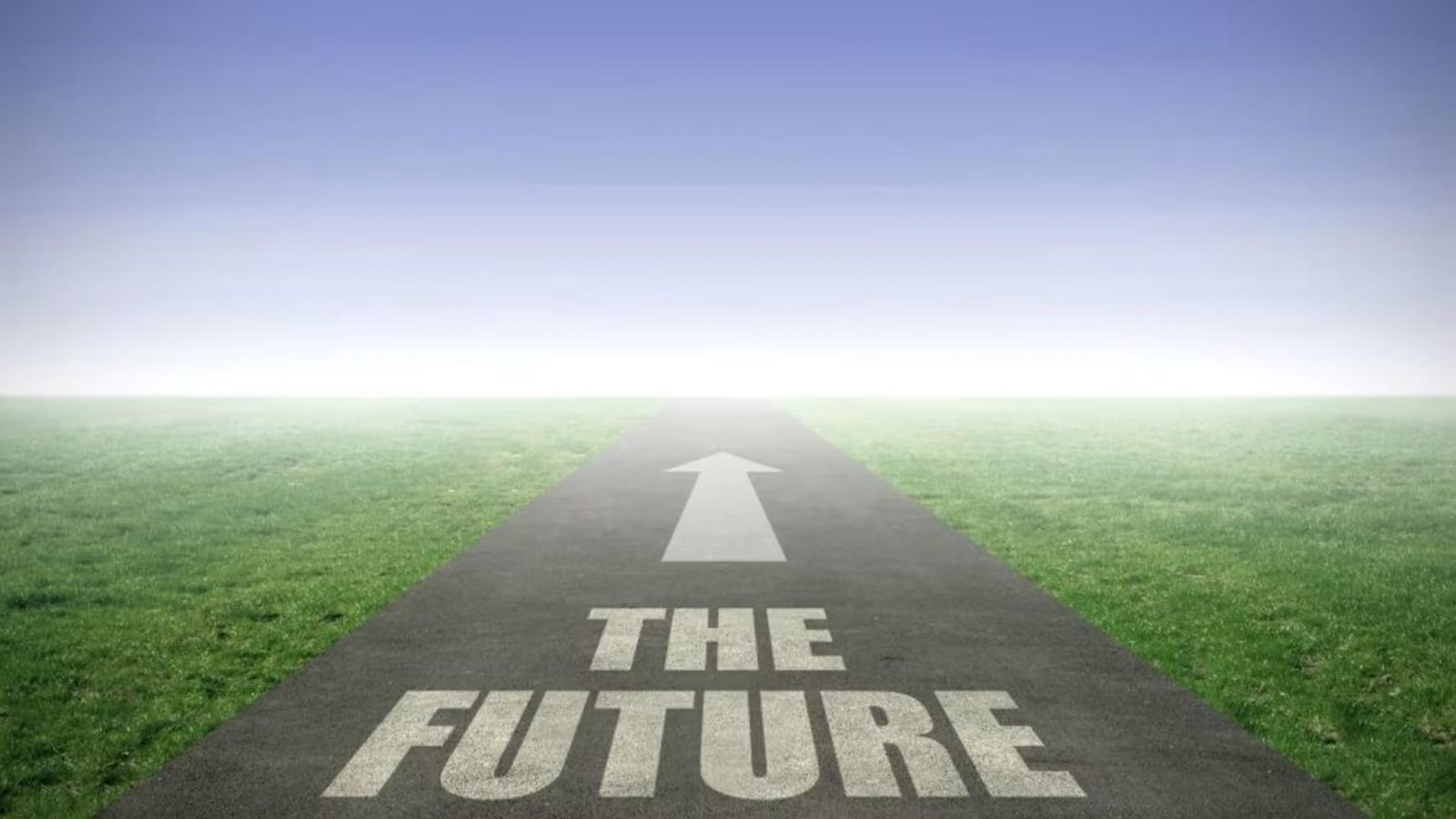 Road with an arrow pointing towards a foggy horizon, with the words “THE FUTURE” painted on the tarmac and grass on both sides