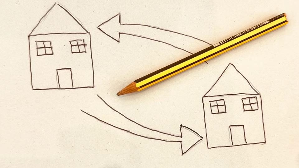 Pencil beside a sketch of two houses with arrows pointing between them, illustrating a timeshare exchange concept