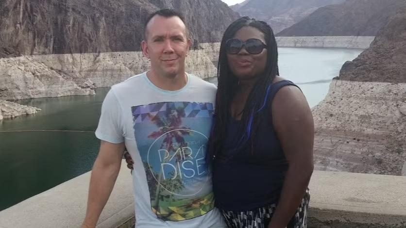 Couple posing by a reservoir viewpoint with rocky mountains in the background