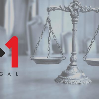 M1 Legal logo beside a silver balance scales statue on a blurred office background