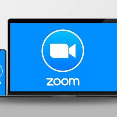 Smartphone and laptop displaying the Zoom logo for Zoom video appointments during Covid-19