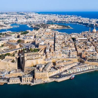 Aerial view of Valletta, Malta, showing the historic peninsula city and surrounding harbours with boats and dense buildings by the sea