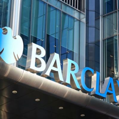 Barclays logo and signage on the exterior of a modern glass office building.