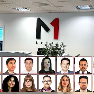 Reception area with large M1 Legal wall logo above a row of staff headshots, representing M1 Legal timeshare lawyers