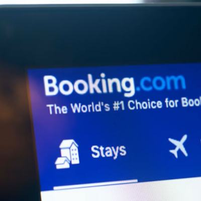Close-up of a laptop screen showing the Booking.com homepage navigation with “Stays” and “Flights” options