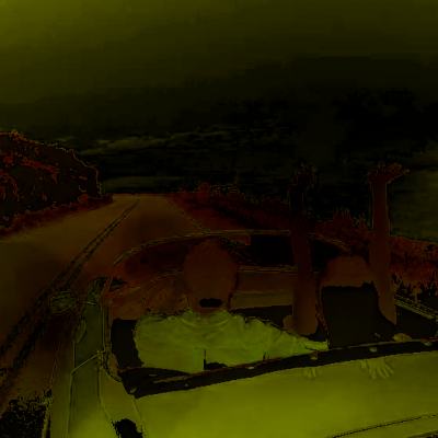 View from a car driving along a rural road under dark, stormy skies with trees lining the roadside