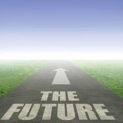 Road with an arrow pointing towards a foggy horizon, with the words “THE FUTURE” painted on the tarmac and grass on both sides