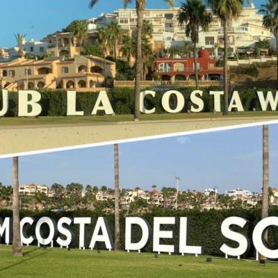 Sign reading “CLUB LA COSTA WORLD” and “WYNDHAM COSTA DEL SOL” in front of a hillside resort with palm trees and apartments under a clear blue sky