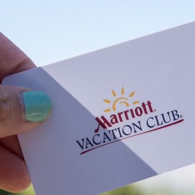 Hand holding a Marriott Vacation Club membership card against a bright sky background