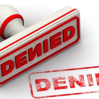 Red denied stamp and rubber stamp on a white background, symbolising a security clearance denial