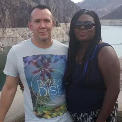 Couple posing by a reservoir viewpoint with rocky mountains in the background